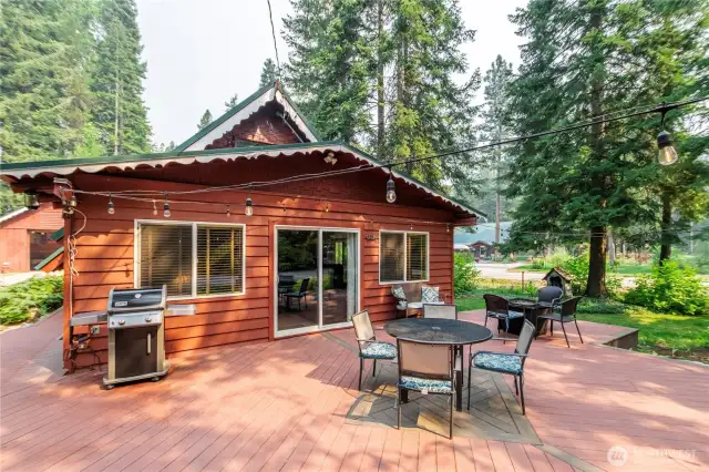 Front Deck with Peek-a-Boo River Views    Relax and enjoy seasonal peek-a-boo river views from the front deck, which includes exterior furniture and a propane grill—perfect for meals or evening gatherings around the fire.