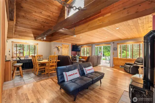 Charming Secondary Gathering Space    Nestled near a propane stove, this secondary living area features vaulted ceilings with beautiful wood beams and bright, airy windows—perfect for relaxing or entertaining.