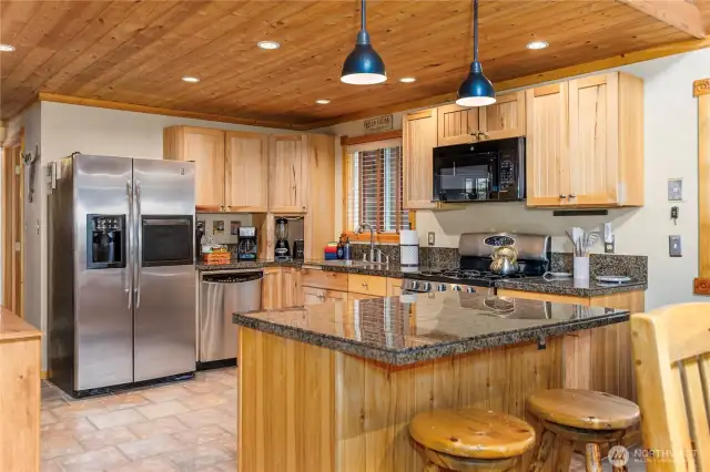 Gourmet Eat-in Kitchen    The kitchen features granite countertops, a central island with pendant lighting, and plenty of storage space underneath—ideal for meal prep and casual dining.