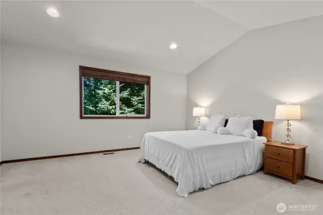 Spacious primary suite has lush green view