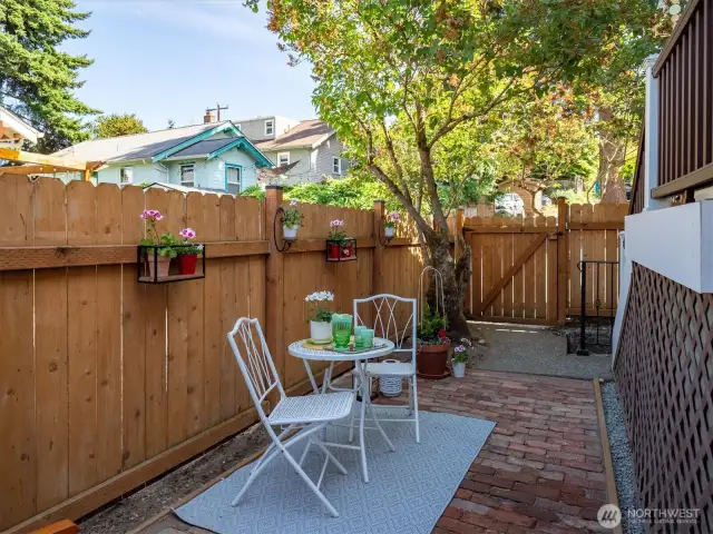 The newer fence and custom brick patio creates this inviting spot for a cup of tea.