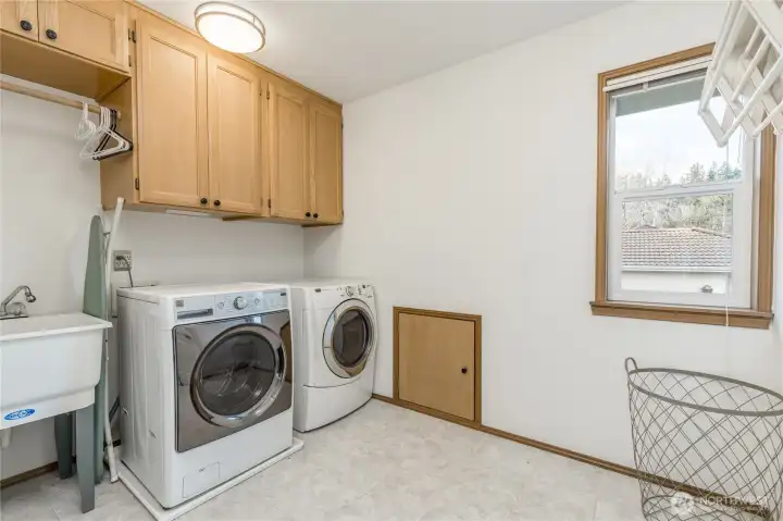 Convenient upstairs laundry with utility sink. Small door provides easy access to attic storage