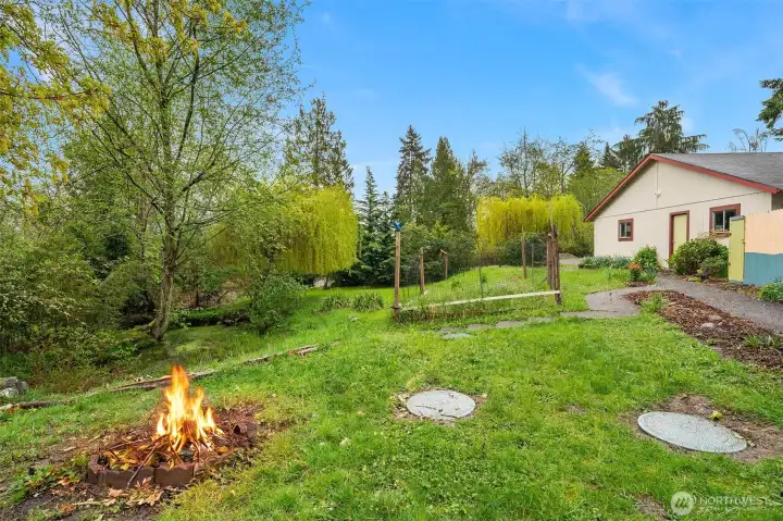 Fun fire pit area overlooks the pond, complete with weeping willow!