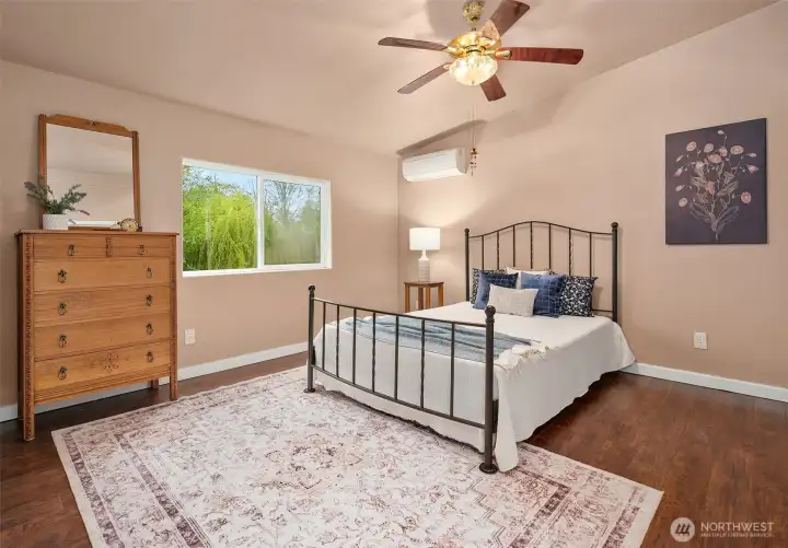 Primary bedroom has its own wing on the northeast side of the home. Generous room with vaulted ceilings, ductlless mini split, walk-in closet and en-suite bath.