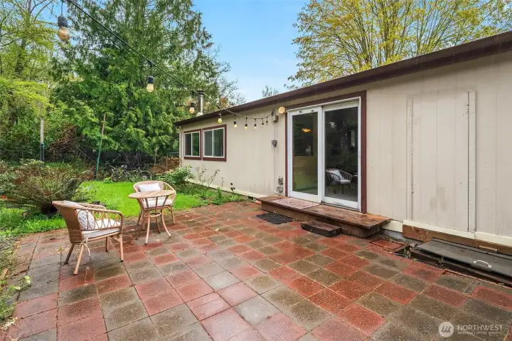 South facing side of the home has paved patio, some privacy fencing and established plantings.