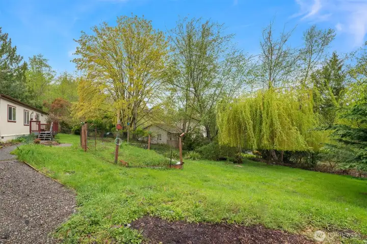 Yard is generous with fenced area for growing veggies and room for lawn games.