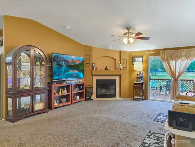 Cozy Living Room – Featuring a wood-burning fireplace for added warmth and ambiance, with doors that open directly to the deck, blending indoor comfort with outdoor access.