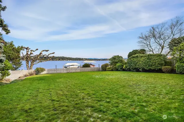 level lawn leads to low bank waterfront and dock.