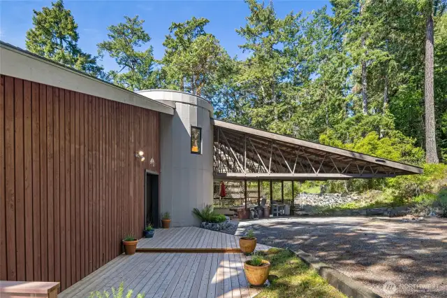 The entrance with decking, covered patio and carport in the back