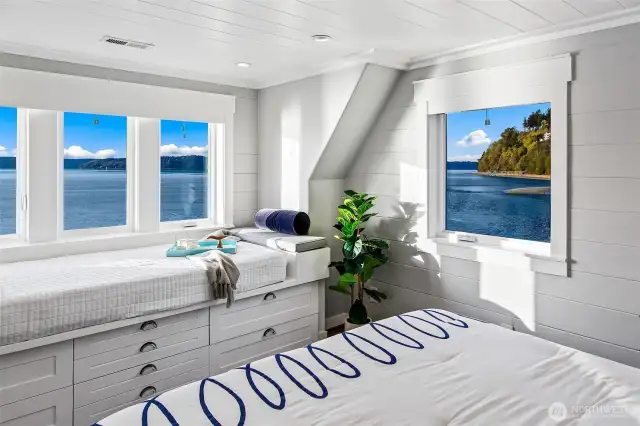 Artful and unexpected, this upper-level bath at 7316 Eastside Drive NE delights with detail. Coastal mosaic tile, a deep soaking tub, and playful navy accents bring personality and polish to this bright space under the eaves. A true jewel box by the sea.