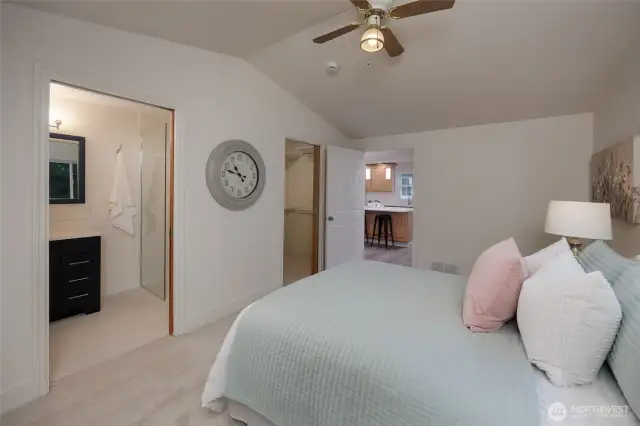 Primary suite with vaulted ceilings, ceiling fan, remodeled en-suite bath and walk in closet.