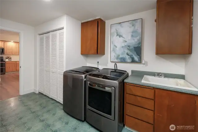 Large laundry room with sink and storage.