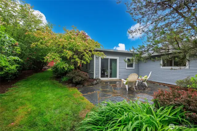 Beautifully landscaped backyard with patio and storage shed.