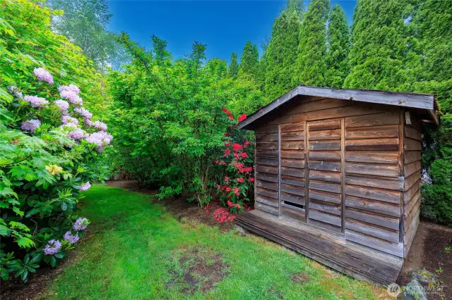 Beautifully landscaped backyard with patio and storage shed.