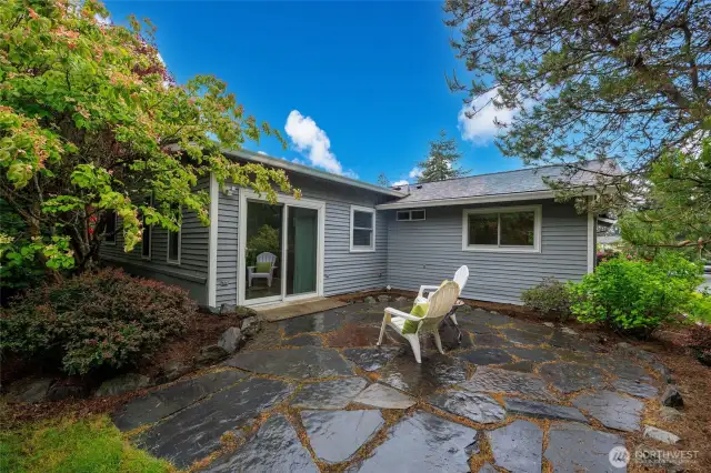 Beautifully landscaped backyard with patio and storage shed.