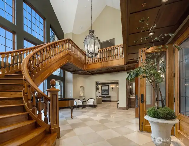 Free-standing Staircase centerpiece is furniture grade solid American white walnut hand-  made by European and American artisans, curves sharply as it rises 14 ft. to the solid 5”  plank walnut mezzanine flooring and the hand-made solid walnut library.