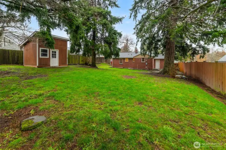Backyard includes a handy storage shed for tools, equipment, or hobby space.