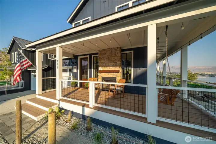 Exterior view of classic covered wraparound porch and double sided fireplace.