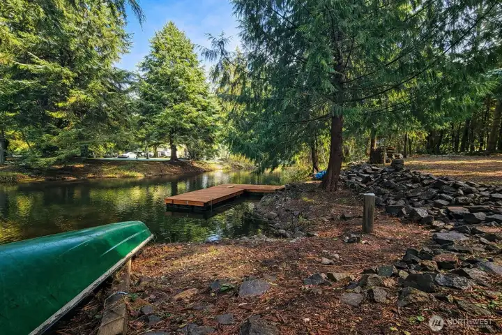 Beautiful waterfront setting with a newer dock, surrounded by mature trees and natural landscaping for added privacy.