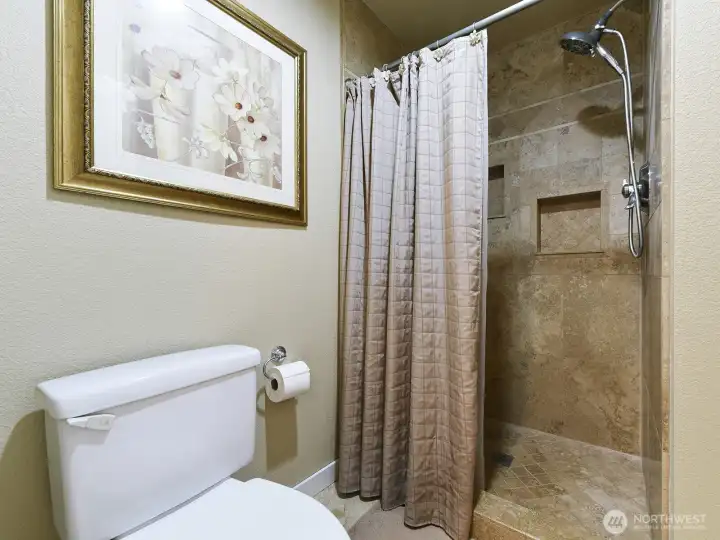 Water closet in primary bath includes toilet & shower for privacy.