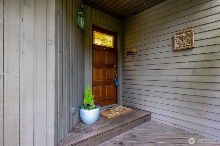The inviting covered front porch leads to the lovely front door.