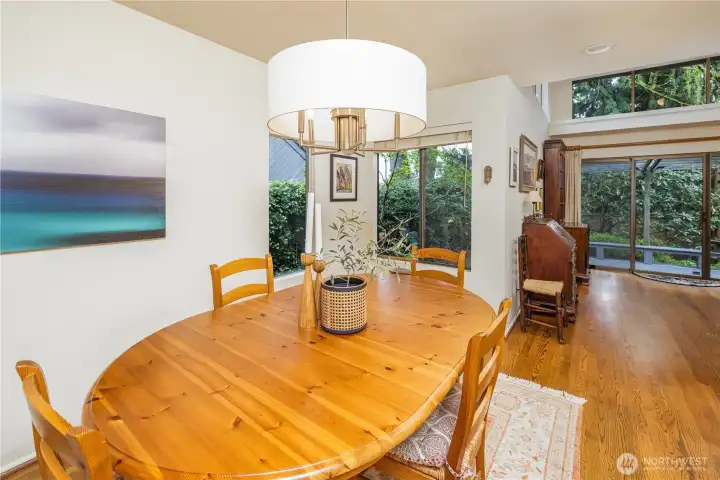 This light-filled dining area offers a warm and inviting setting, with large windows that bring in natural light and peaceful garden views. Open to the main living space, it creates an easy flow for entertaining while maintaining a sense of intimacy for everyday meals.