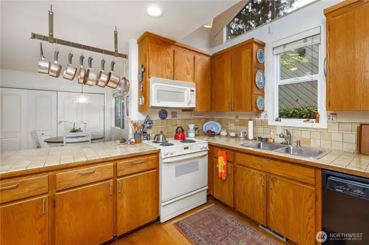 The spacious kitchen offers abundant storage and workspace, providing a fantastic opportunity to customize and make it your own. It opens seamlessly to a generous breakfast nook with direct access to the side yard and garage, creating an easy, functional flow for everyday living and entertaining.