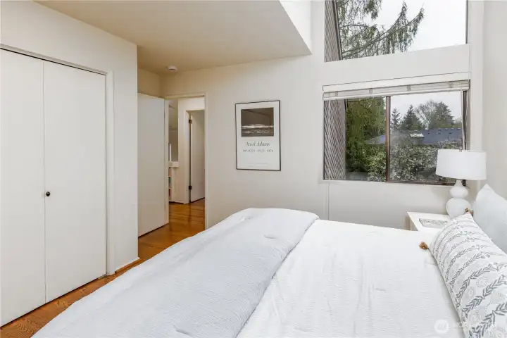 The second bedroom upstairs features a wall of view windows and ample closet space.