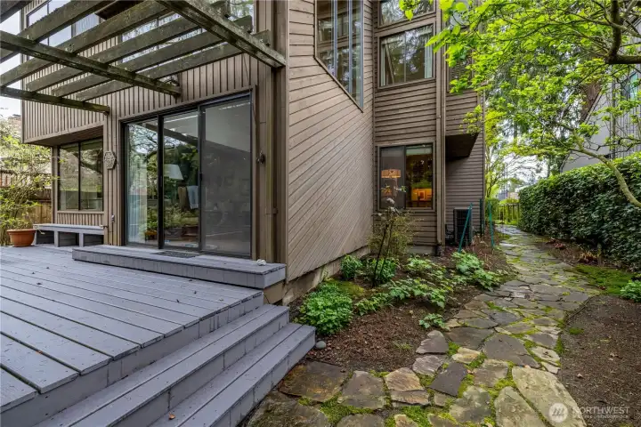 The side yard offers a peaceful extension of the garden, with winding stone pathways and lush plantings that create a sense of privacy and tranquility. Ideal for gardening enthusiasts, this serene space provides ample opportunity to cultivate and enjoy a variety of plantings in a quiet, natural setting.