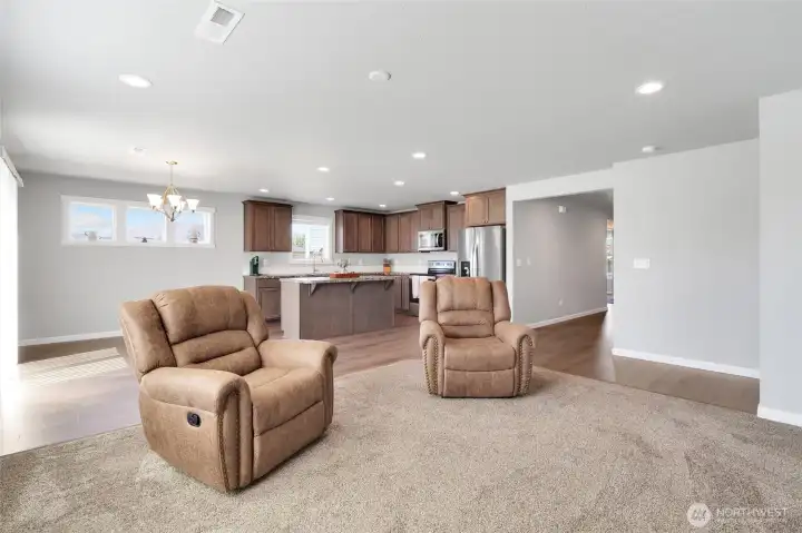 Wide view of open concept living room that connects to the kitchen and dining space.