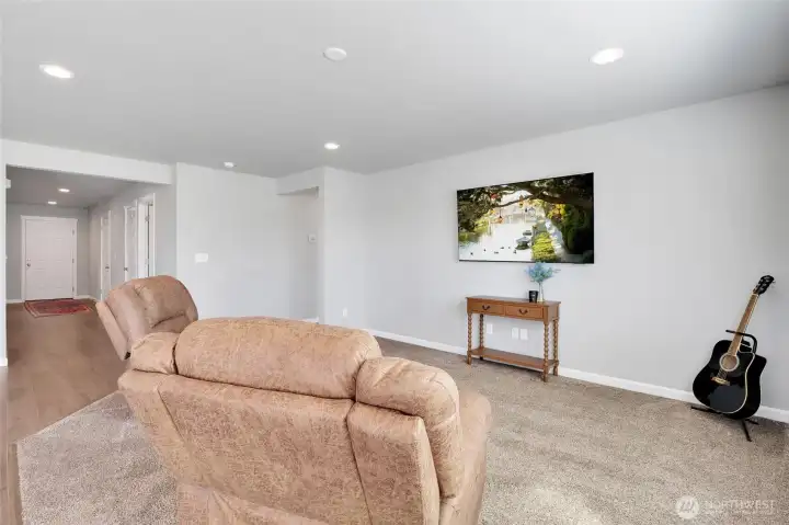 Inviting living area with plush carpeting and open sight lines to the kitchen and main hallway.