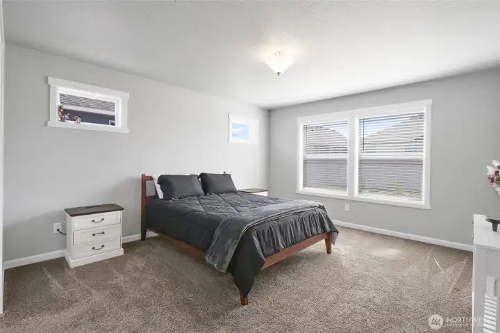 Comfortable primary bedroom with plush carpeting.