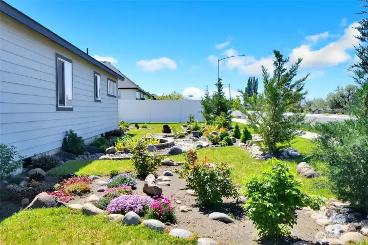 Spacious yard featuring low maintenance landscaping.
