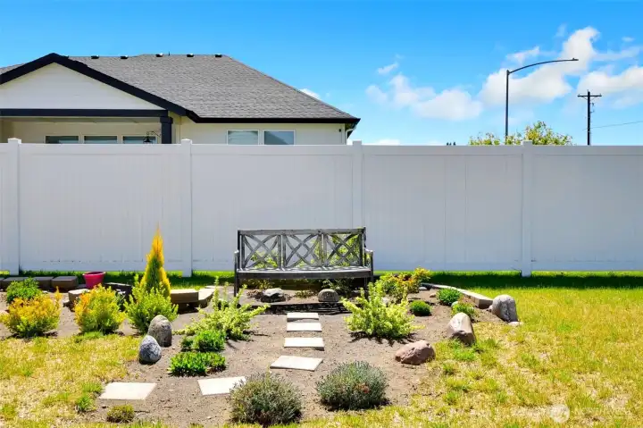 Charming backyard seating area with stepping stone path.