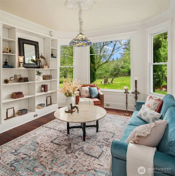 Library is opposite the kitchen with a sweet bay window and lots of built in shelving. Fir floors and period moulding throughout the home.