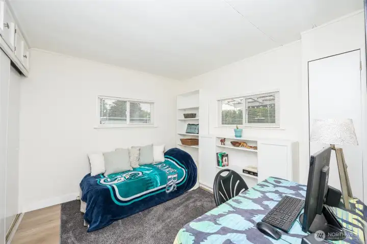 2nd bedroom with built-in shelves and storage above the closet.