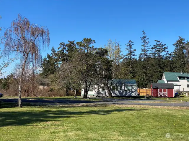 Just wait until these maple tree leaf out! Mature apple trees too. The little red shed allows for some storage. White house in the back ground is located on the property to the north and not part of this listing.