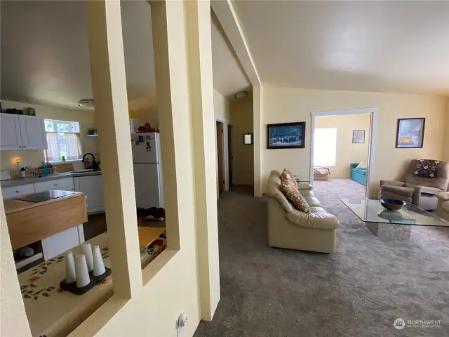 Middle of frame looks down hallway to guest bed/bath.