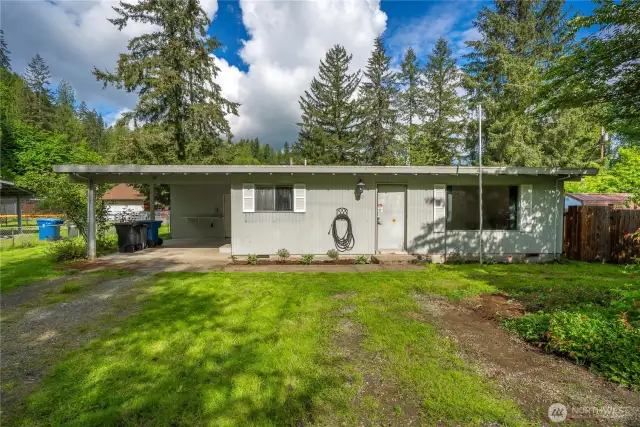 Front elevation of the home framed by mature evergreens—welcome to your peaceful escape with endless potential.