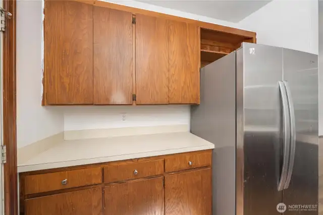 Additional cabinetry, counter space, and easy access to the stainless steel refrigerator—ideal for pantry storage, small appliances, or your morning coffee station.