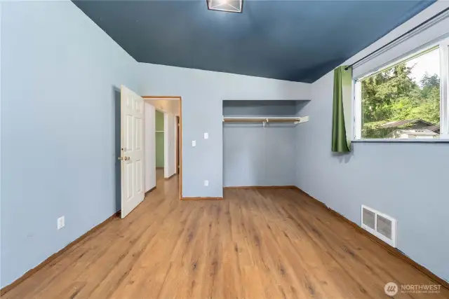 The open closet nook provides versatile storage options, and the vaulted ceiling adds a sense of openness and airiness to the space.