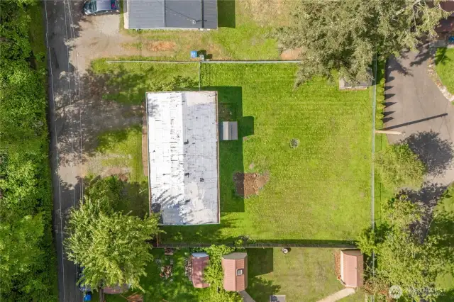 Bird’s-eye view of your private retreat! This overhead shot showcases the home’s placement on a generous, fully fenced lot—perfect for future garden beds, pets, or play. Nestled in a quiet neighborhood, the lot offers privacy, usable space, and potential for expansion or outdoor customization.