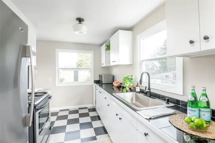 The refreshed kitchen is both functional and charming, overlooking the side and backyard.