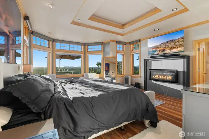 West facing primary suite with walls of glass and a gas fireplace.