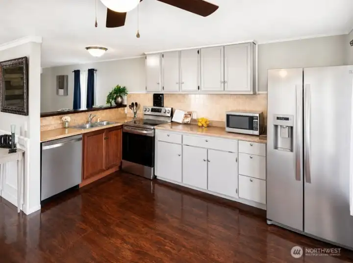 Updated kitchen with abundant grey cabinetry, beautiful countertops, stainless steel appliances, and functional open layout.