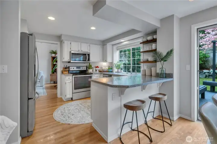 Around the corner from the living room. To our right is dining, Family Room & backyard access. Breakfast bar for quick meals & good chats with the cook!