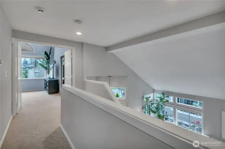 Up the stairs.  Primary suite straight ahead; two bedrooms + bath just behind us.