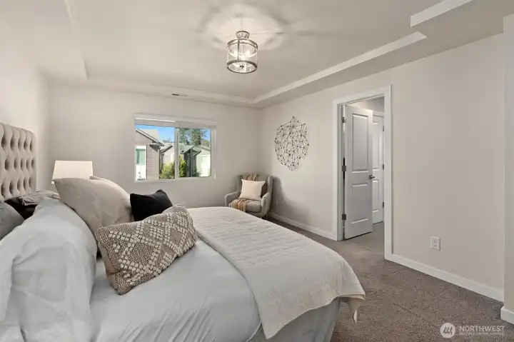 The spacious primary bedroom is located on the upper level, just down the hall from the two secondary bedrooms.