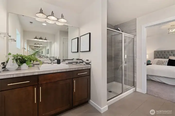 Spacious primary ensuite bath with walk-in shower and dual vanities.