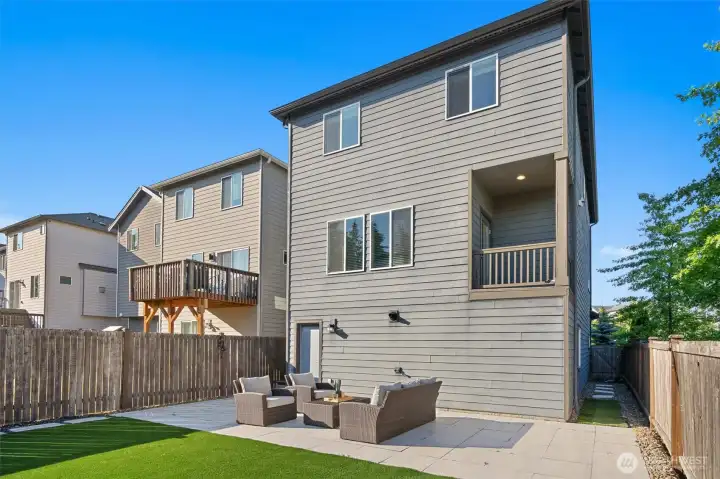 The fully fenced backyard offers low-maintenance living with new turf and paver hardscaping.